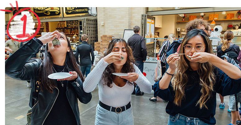 Three students eating raw oysters