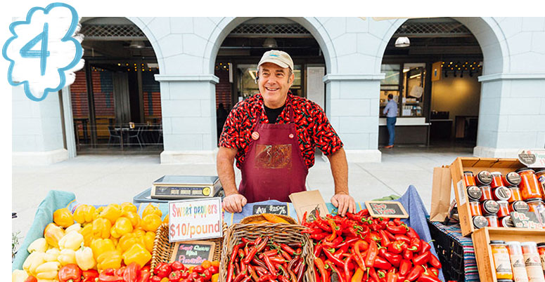 Person with peppers at farmers market booth