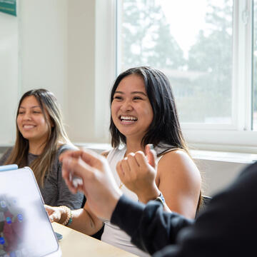 Student in classroom smiling and engaging in discussion