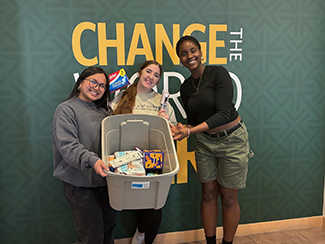 Three students pose with supplies