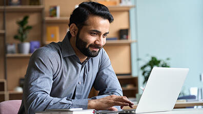 man looking at his laptop, smiling