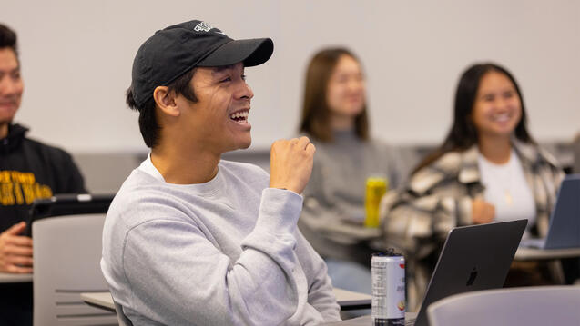 USF student in class listening and laughing about something professor said