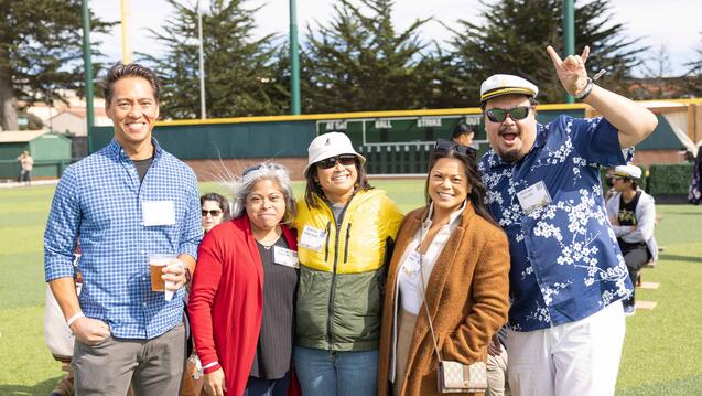 USF alumni smiling on a baseball diamond