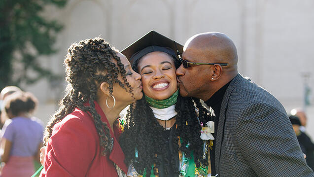 parents celebrating commencement with daughter on campus