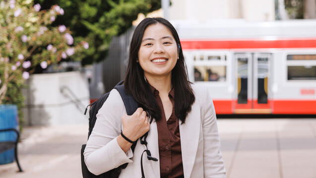 USF student wearing backpack smiling and posing on campus