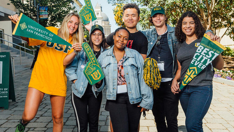 Students holding university swag