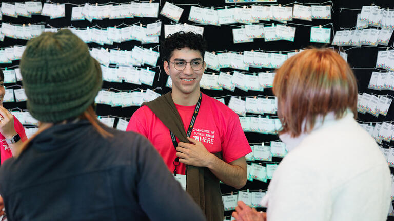 student hands out name cards at an event