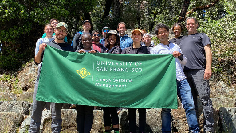 students in nature holding a banner for energy systems management