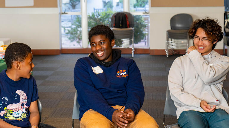 usf mentor and mentees sit in chairs and laugh together