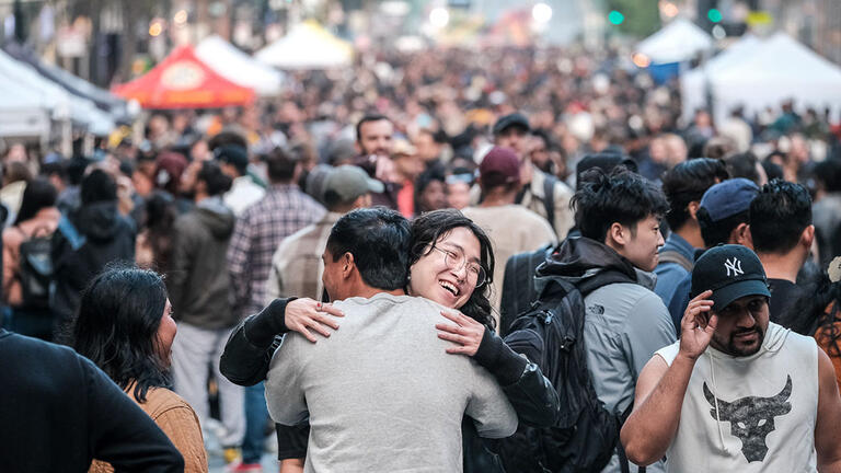 Two people hugging in a crowd.