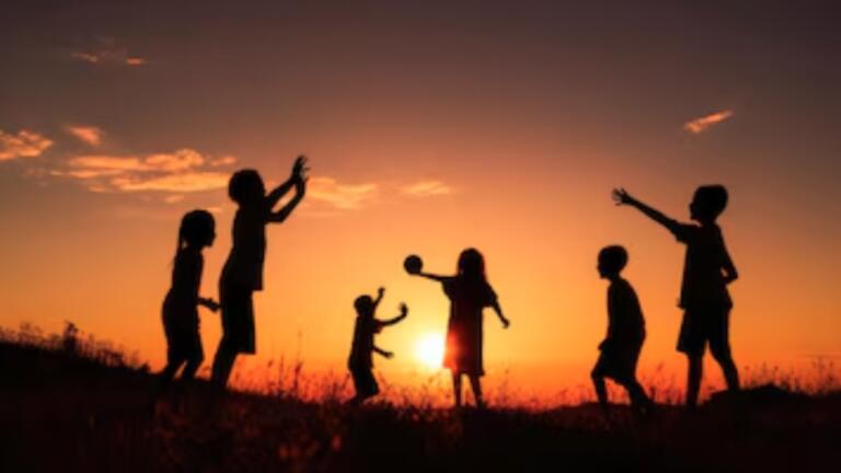 Silhouette of children playing catch