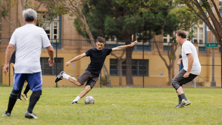 Three soccer players on the field.