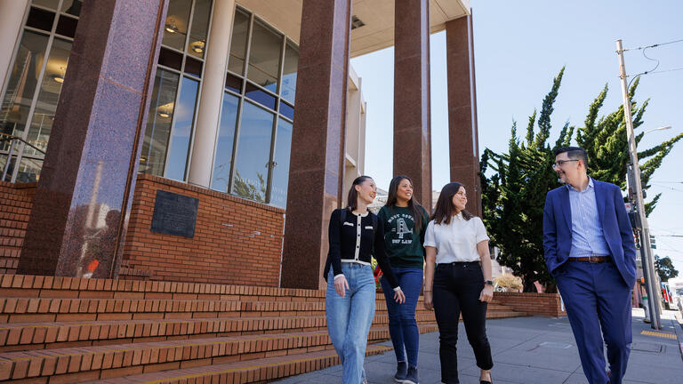 students walk with professor on usf campus