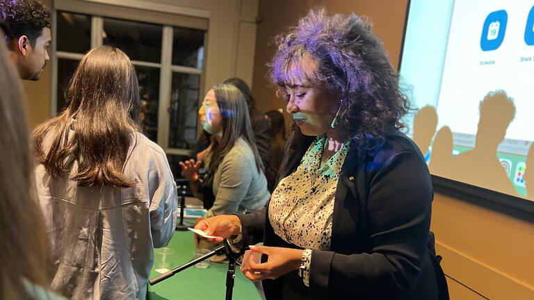 person hands out a business card at a conference