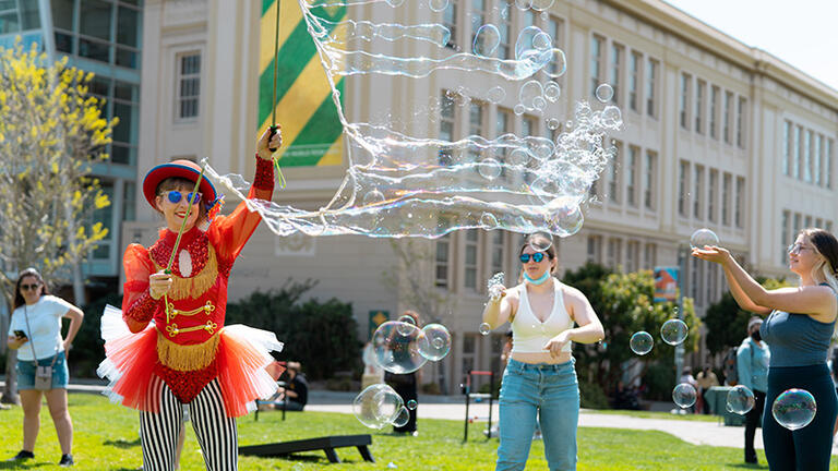 Three people playing with bubbles