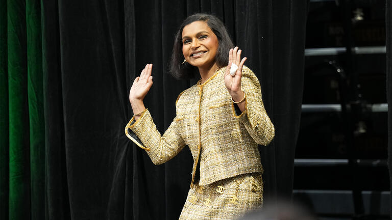 Mindy Kaling waving at audience from stage