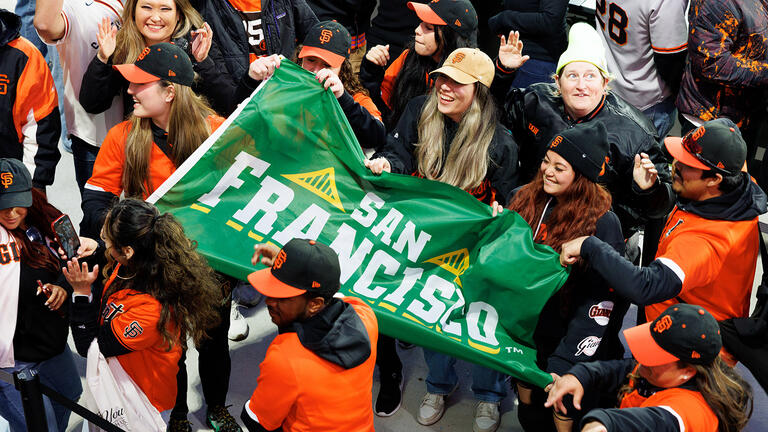 usf community members hold san francisco banner during giants game