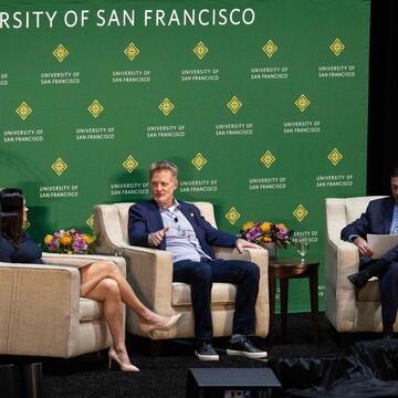 Steve Kerr with two other speakers sitting on a stage