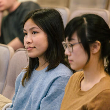 two students sit in lecture hall