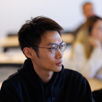 student in glasses listens in class