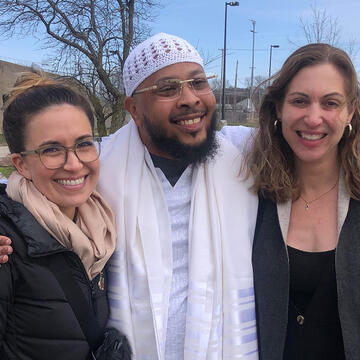 Three people hugging and smiling