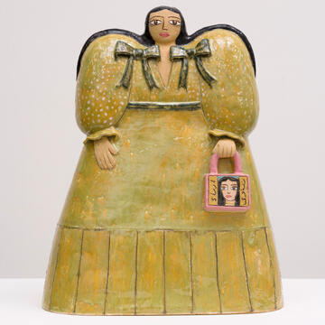 ceramic figurine of person in dress holding bag
