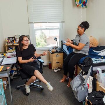 two students socializing in a St. Anne's room