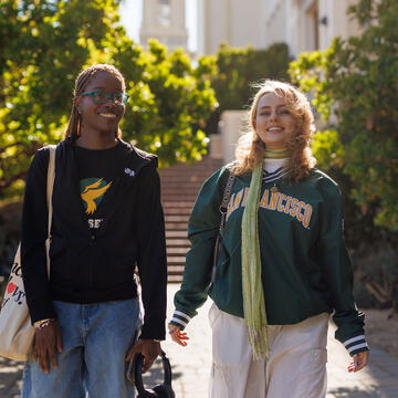 Two students walking across campus