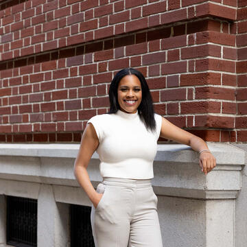 Sport Management student posing in front of building.