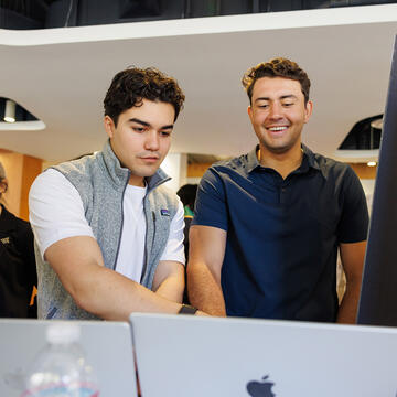 two students look over laptops