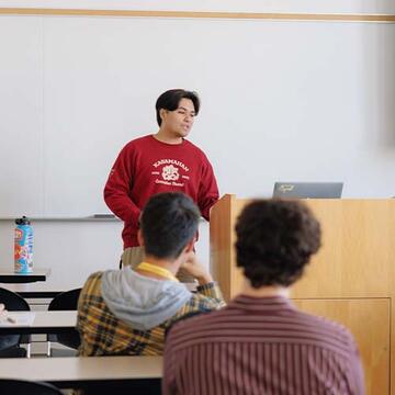 Student presenting in front of a classroom