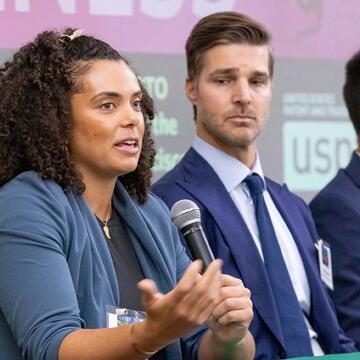 Three students speaking on a panel