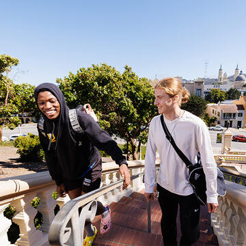 Two USF students climbing the Lone Mountain stairs