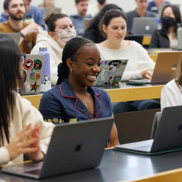 Law student sitting in lecture hall, smiling