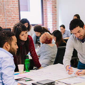 Graduate students gathered around a table, working on a project