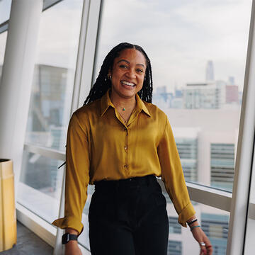 Sport Management student in yellow shirt smiling in Chase Center