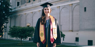 Kayla Tabari in graduation gown near St. Ignatius Church.