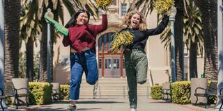 Two students jumping in the air