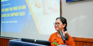 Professor Ann Nguyen speaking at a podium