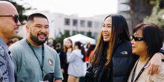 Four people standing together and smiling