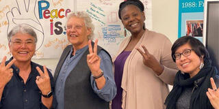 Four people giving peace signs