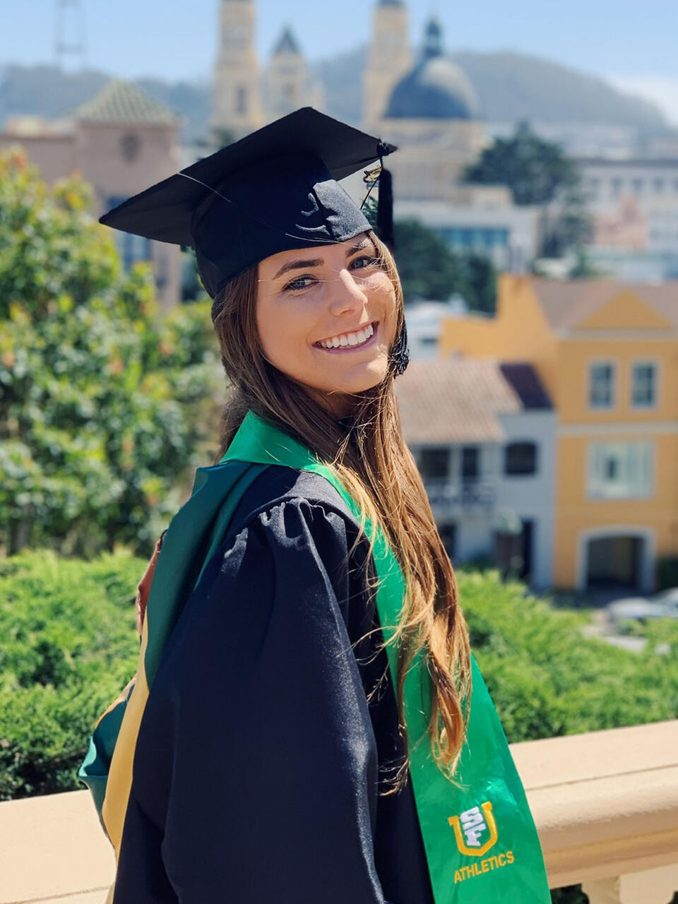 Student in cap and gown on Lone Mountain