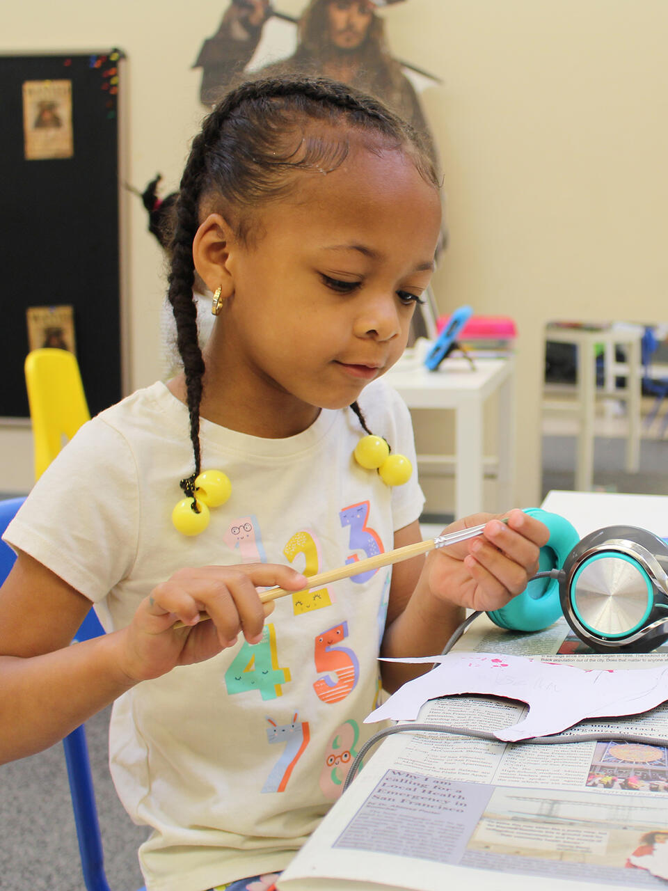 elementary school student holding paintbrush